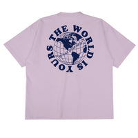 Heavyweight cotton tee in pale grape purple featuring the APT.4B Globe logo. Represents the brand's journey from local Queens roots to global influence.