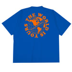 Heavyweight cotton tee in royal blue featuring the APT.4B Globe logo. Represents the brand's journey from local Queens roots to global influence.